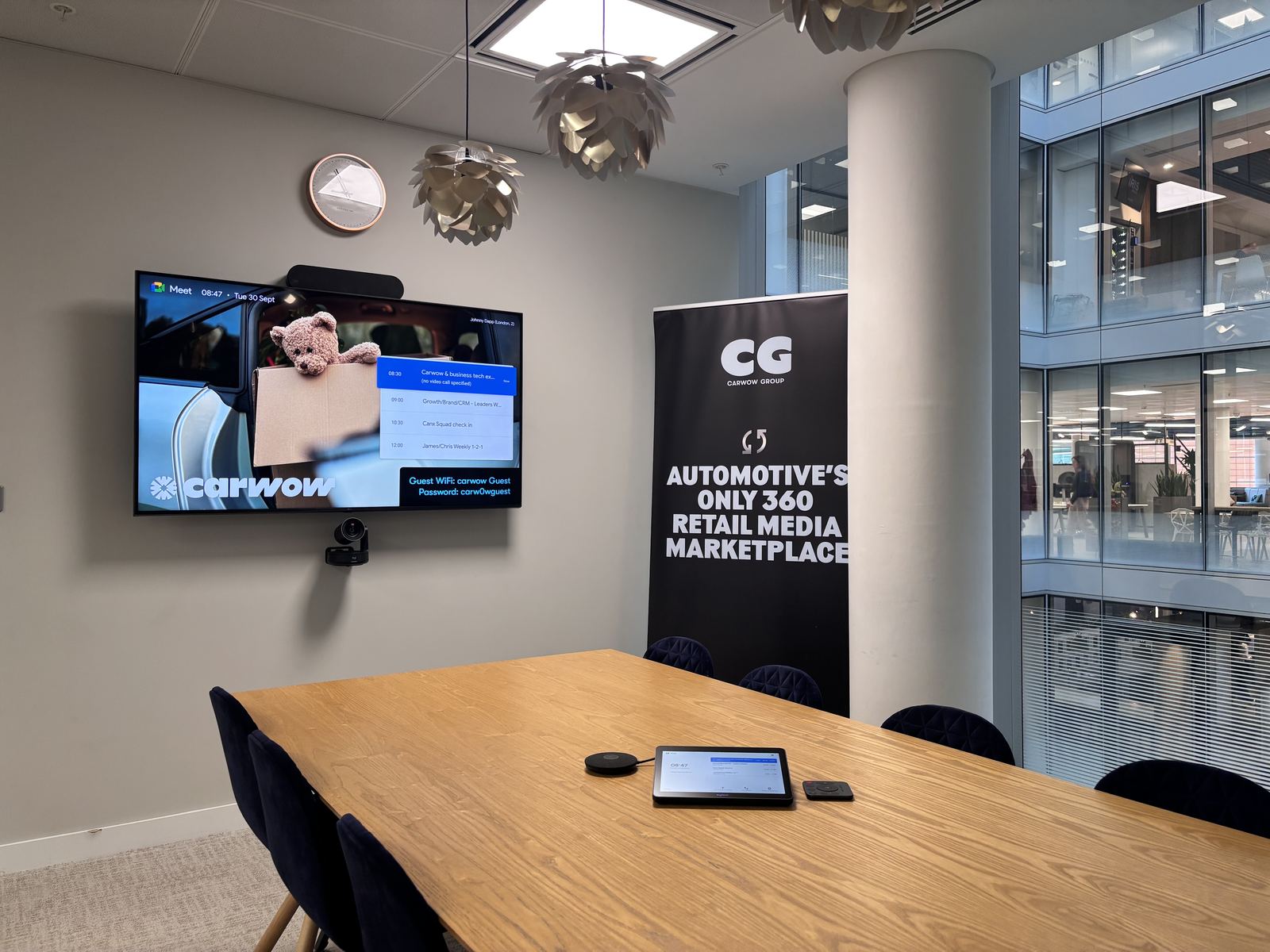 Carwow meeting room with a wall display beside a branded event banner