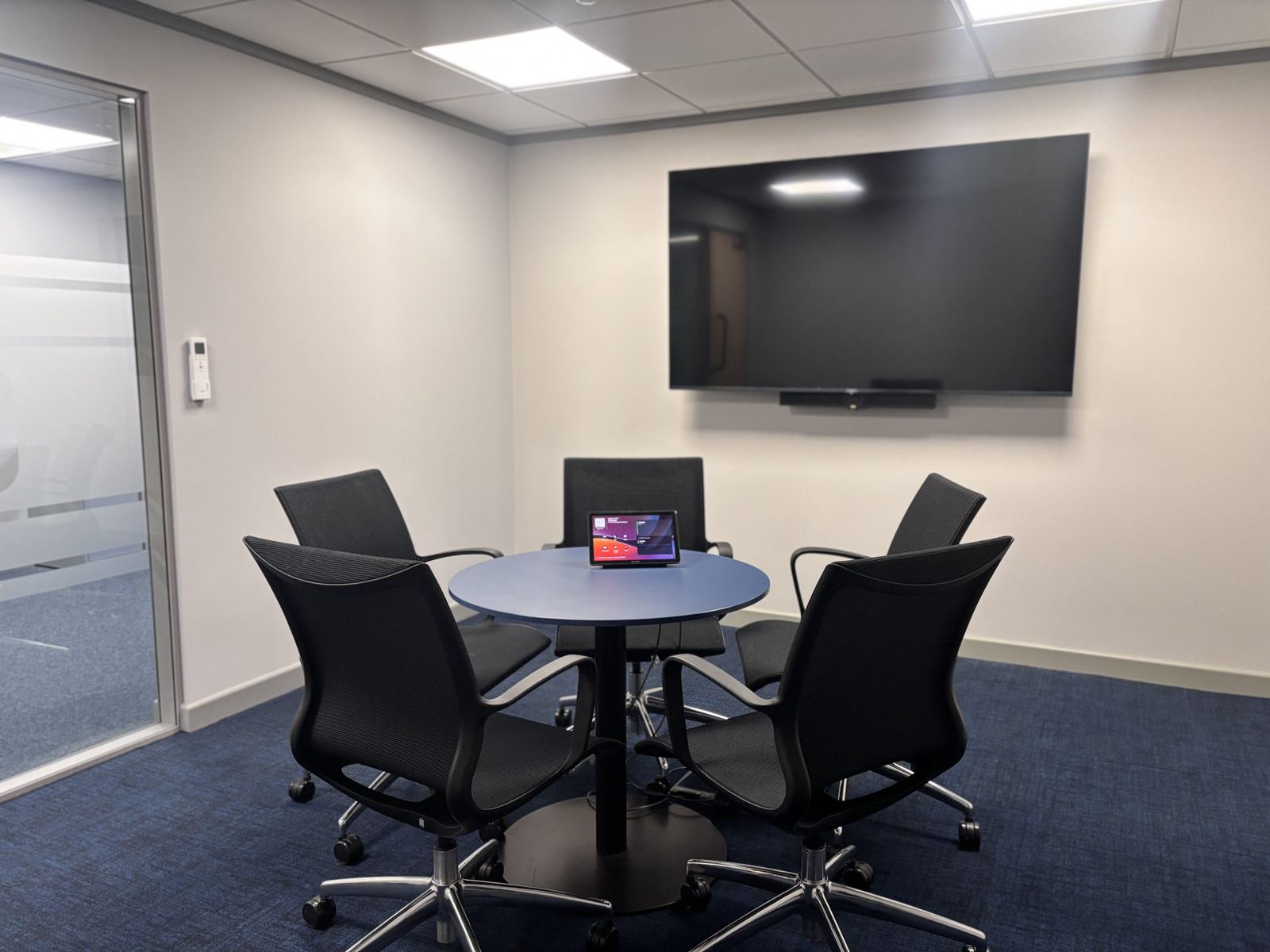 Small Menzies Aviation meeting room with a round table and wall display