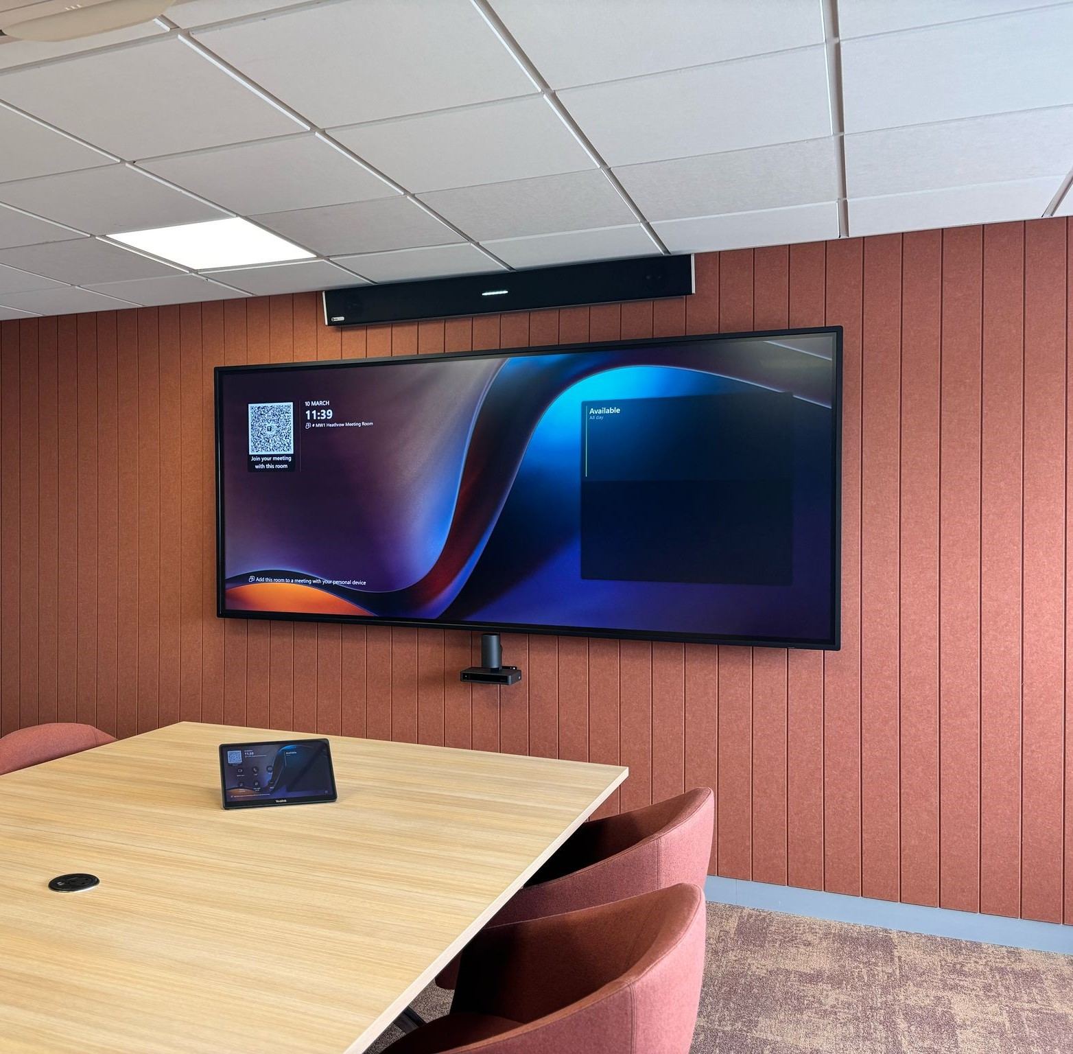 Menzies Aviation executive office with an ultra-wide display on a terracotta wall