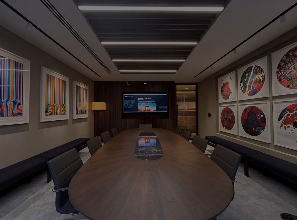 VR Capital boardroom with an oval timber table, ultra-wide display and colourful artwork