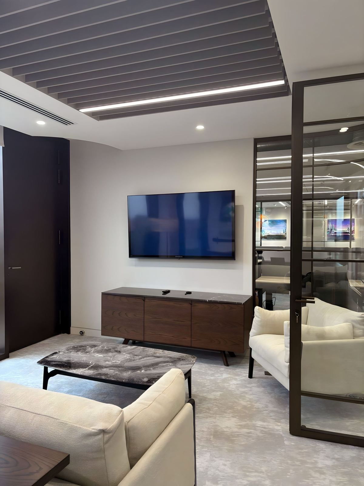 VR Capital breakout lounge with sofas and a wall-mounted display